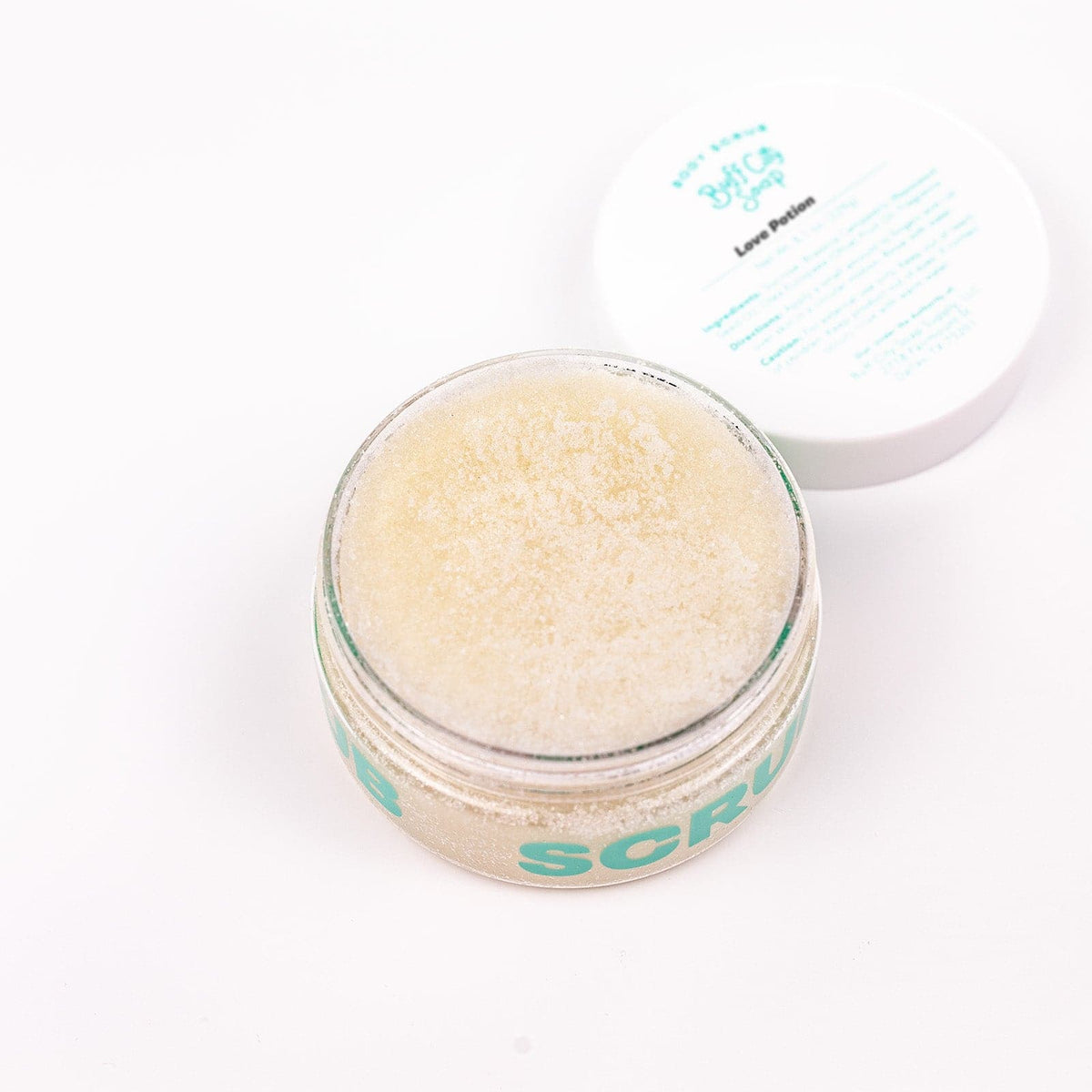 Open can of Buff City Soap's love potion body scrub with its lid next to it