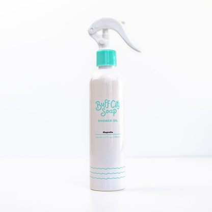 Magnolia Shower Oil spray bottle with teal finishes against white background